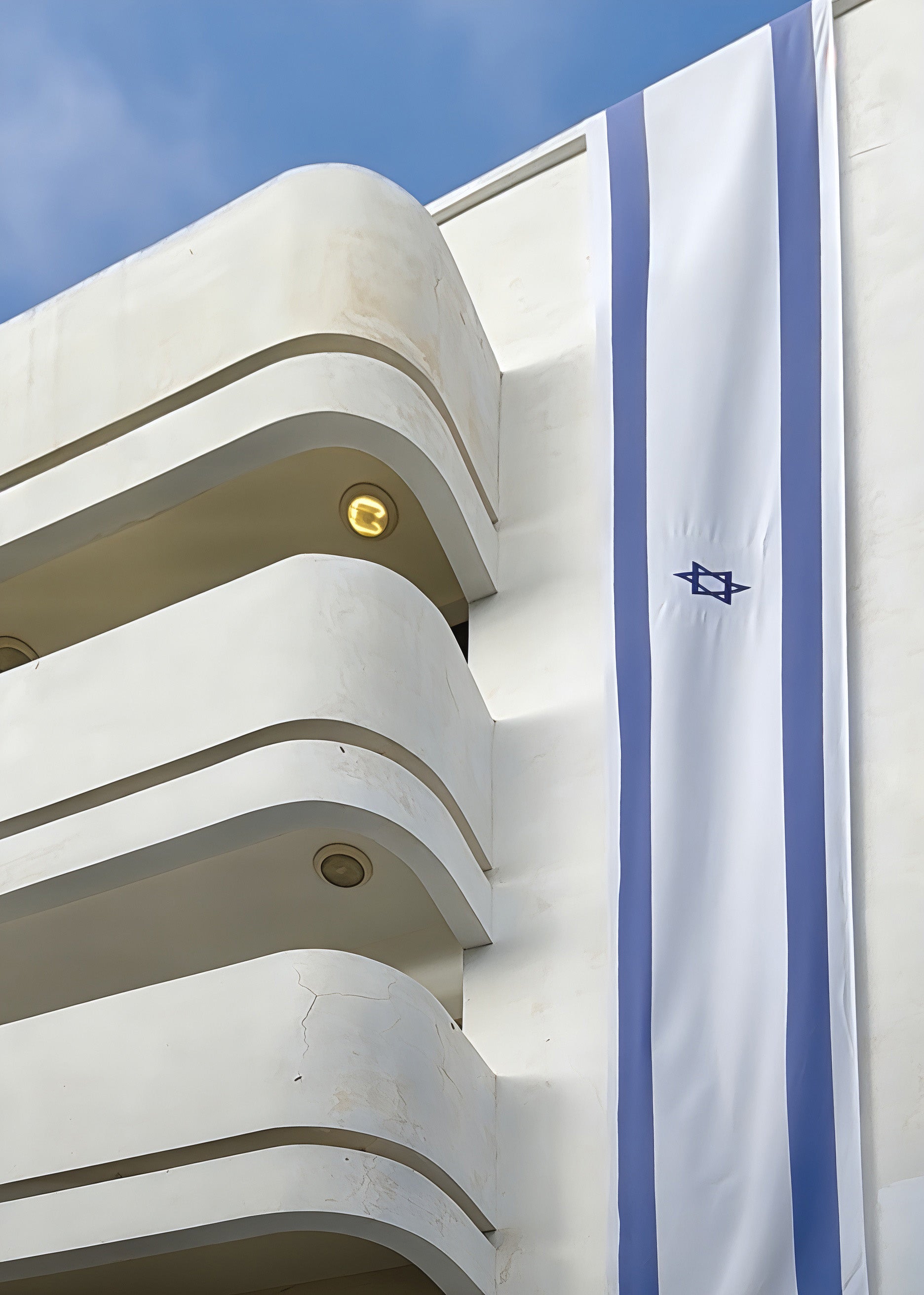 Bauhaus at Dizengoff architecture featuring an Israeli flag on a modern building in Tel Aviv.