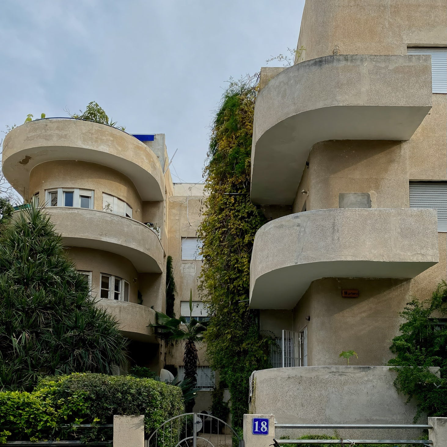 Bauhaus Tel Aviv architecture featuring curved balconies and greenery in Tel Aviv, Israel, ideal for wall art.
