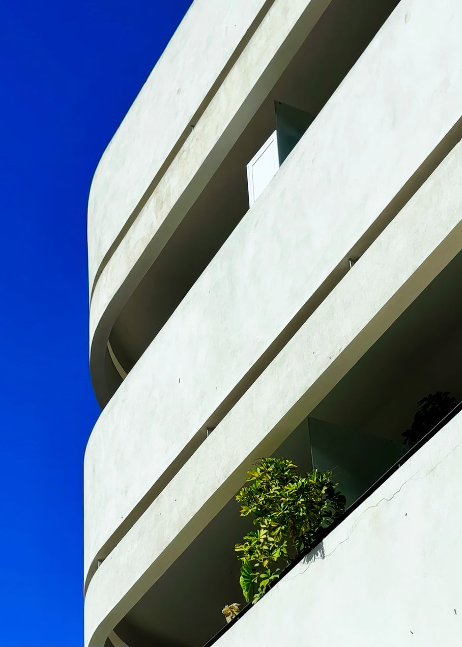 Dizengoff Square balcony with greenery in Tel Aviv under a clear blue sky, showcasing modern architecture.