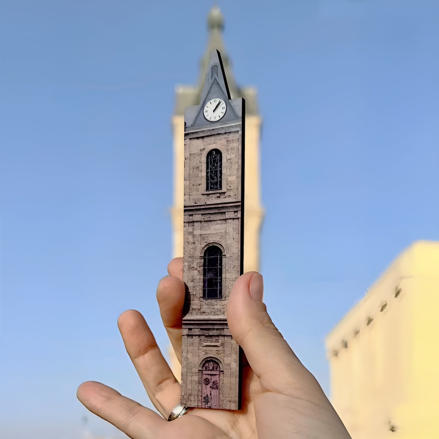 THIS IS TEL AVIV Israel Souvenir — City Miniature of Jaffa clock tower held in hand against clear blue sky.