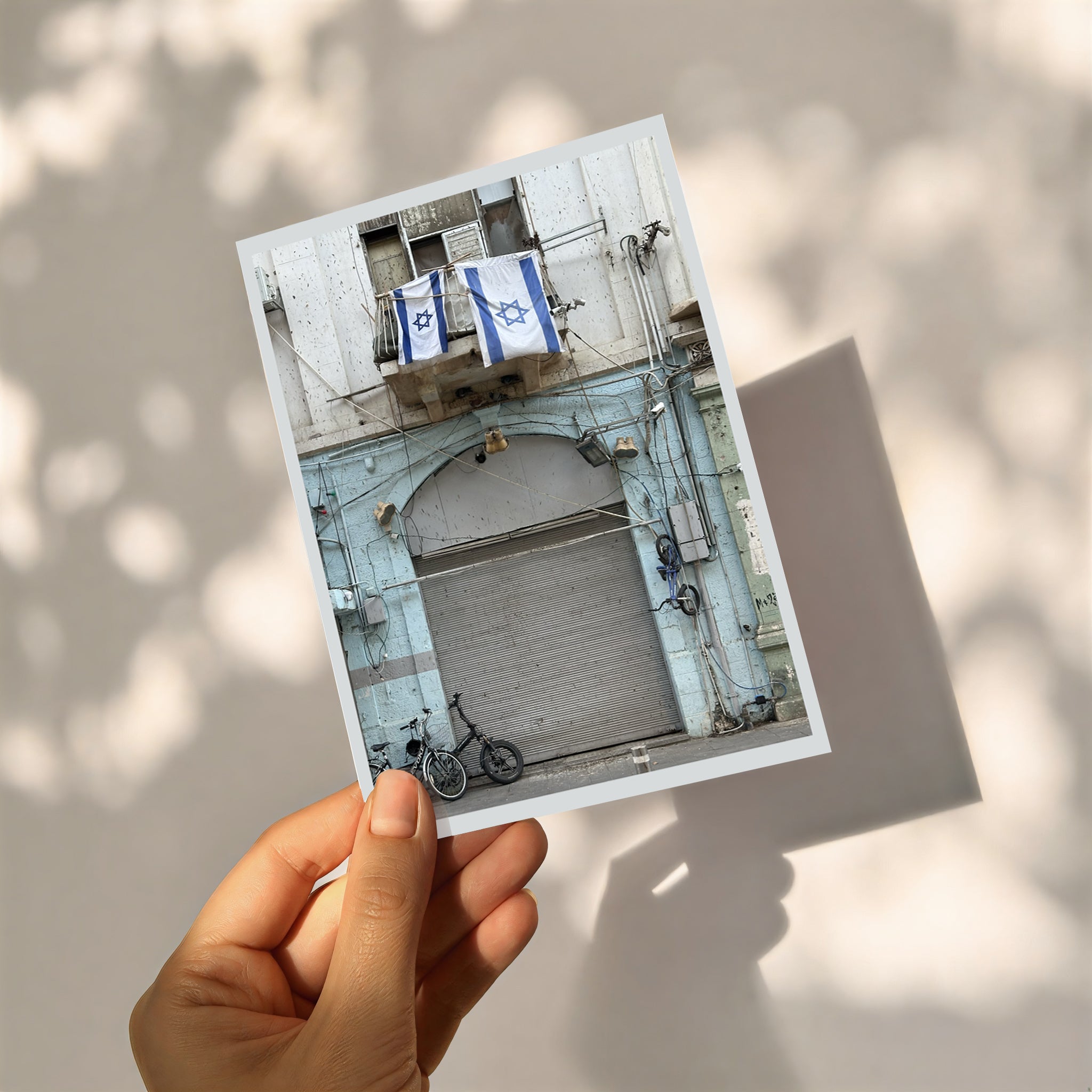Letter from Tel Aviv photo print featuring a building with blue and white flags and a bicycle.