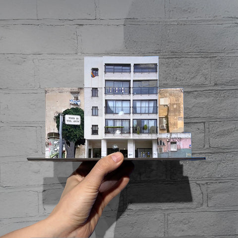 THIS IS TEL AVIV Israel Souvenir — Architecture Miniature set with a detailed building design held against a grey wall.